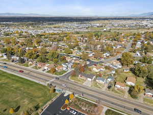 Aerial view of property and surrounding area featuring a mountain backdrop and nearby suburban area