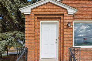 View of exterior entry featuring brick siding
