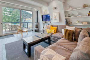 Living area with a wood stove, tile patterned floors, and recessed lighting