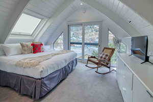 Bedroom featuring light carpet, multiple windows, access to outside, wood ceiling, and a skylight