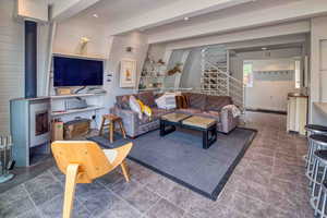 Living room featuring a wood stove, stairway, built in features, and beamed ceiling