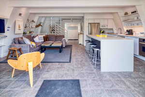 Living area featuring beam ceiling and stairway