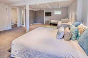 Bedroom featuring light colored carpet, beamed ceiling, and recessed lighting