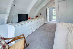 Bedroom with light colored carpet and wooden ceiling