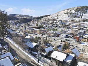 Snowy aerial view with a mountain view and a residential view