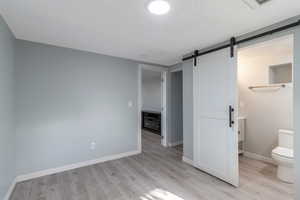 Master bedroom with a Bathroom featuring light wood-type flooring