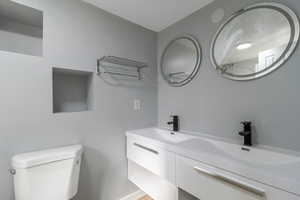 Full bath featuring double vanity and toilet