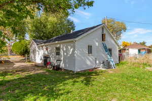 View of side of property featuring a central air condition unit and a shingled roof