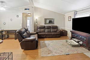 Living room with light wood-type flooring and ornamental molding
