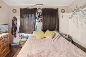 Bedroom featuring dark wood-style floors and baseboards