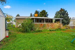 Rear view of house featuring a yard
