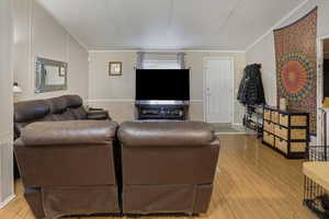 Living area featuring light wood-style floors and ornamental molding