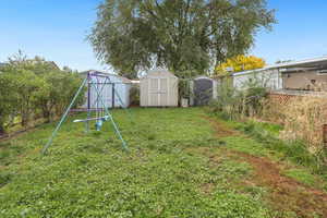 View of grassy yard featuring a shed