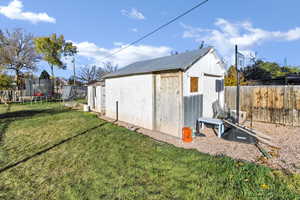 View of shed featuring a trampoline and a fenced backyard