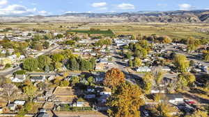 Aerial overview of property's location with nearby suburban area and a mountainous background