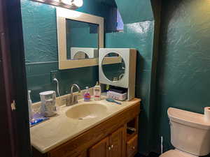 Half bathroom featuring a textured wall and vanity