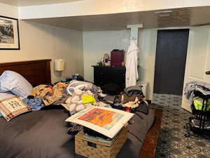 Bedroom featuring a textured wall, a textured ceiling, and a closet
