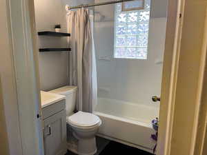 Bathroom featuring vanity and shower / bathtub combination with curtain