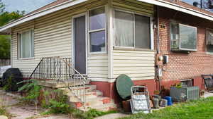 View of property exterior featuring brick siding and roof with shingles