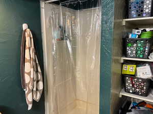 Bathroom with a textured wall and a shower with shower curtain