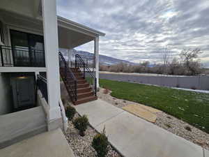 View of green lawn featuring a mountain view and stairway