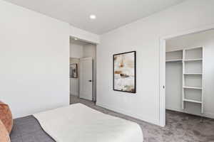 Bedroom with carpet flooring, a walk in closet, and recessed lighting. Model Home