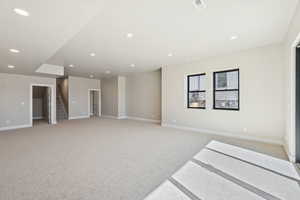 Unfurnished room featuring light colored carpet, stairs, and recessed lighting