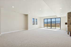 Spare room featuring a mountain view, light carpet, and recessed lighting