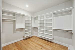 Walk in closet with light wood-style flooring