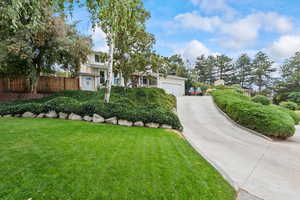 View of front of home featuring heated driveway, basement entrance, and an attached garage
