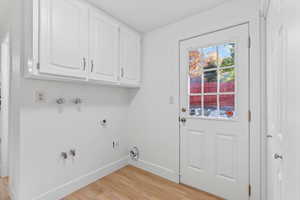 Laundry room with cabinet space, hookup for a washing machine, and exterior exit