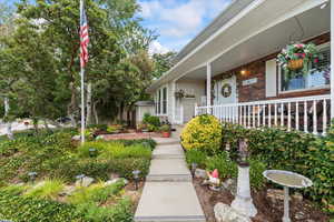 Entrance to property featuring a porch and brick siding