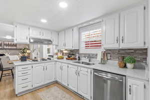 Kitchen featuring a peninsula, stainless steel appliances, white cabinets, plenty of natural light, and recessed lighting