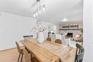 Dining area with light wood-style floors and a fireplace