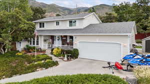 Traditional-style home featuring covered porch, a mountain view, an attached garage, and heated driveway