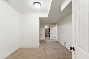 Spare room featuring light colored carpet and baseboards