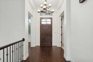 Foyer featuring dark wood finished floors and a chandelier