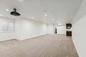 Basement with light carpet and recessed lighting