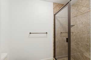 Full bathroom featuring a stall shower and toilet