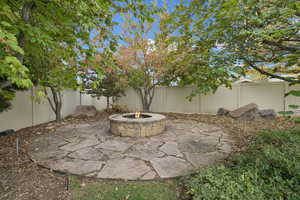 Fenced backyard featuring a patio area and a fire pit