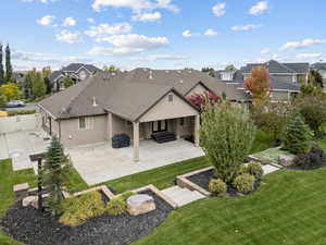 Rear view of house featuring a patio area, stucco siding, and a shingled roof