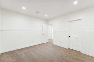 Carpeted spare room featuring wainscoting and recessed lighting