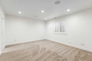 Empty room featuring recessed lighting and light carpet