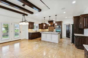 Kitchen featuring dark brown cabinetry, backsplash, decorative light fixtures, a chandelier, and beamed ceiling