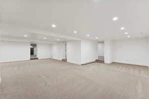 Finished below grade area featuring recessed lighting and light carpet