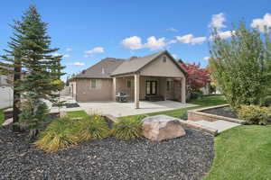 Back of house with a patio, stucco siding, and a yard