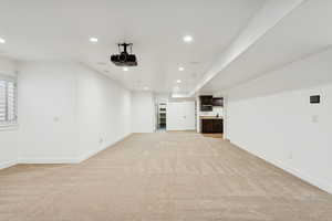 Unfurnished living room featuring recessed lighting and light colored carpet