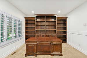 Unfurnished office featuring a decorative wall, light carpet, recessed lighting, and wainscoting