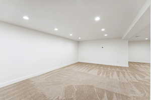 Finished below grade area with recessed lighting and light carpet