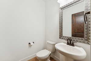 Half bathroom with baseboards and tile patterned floors